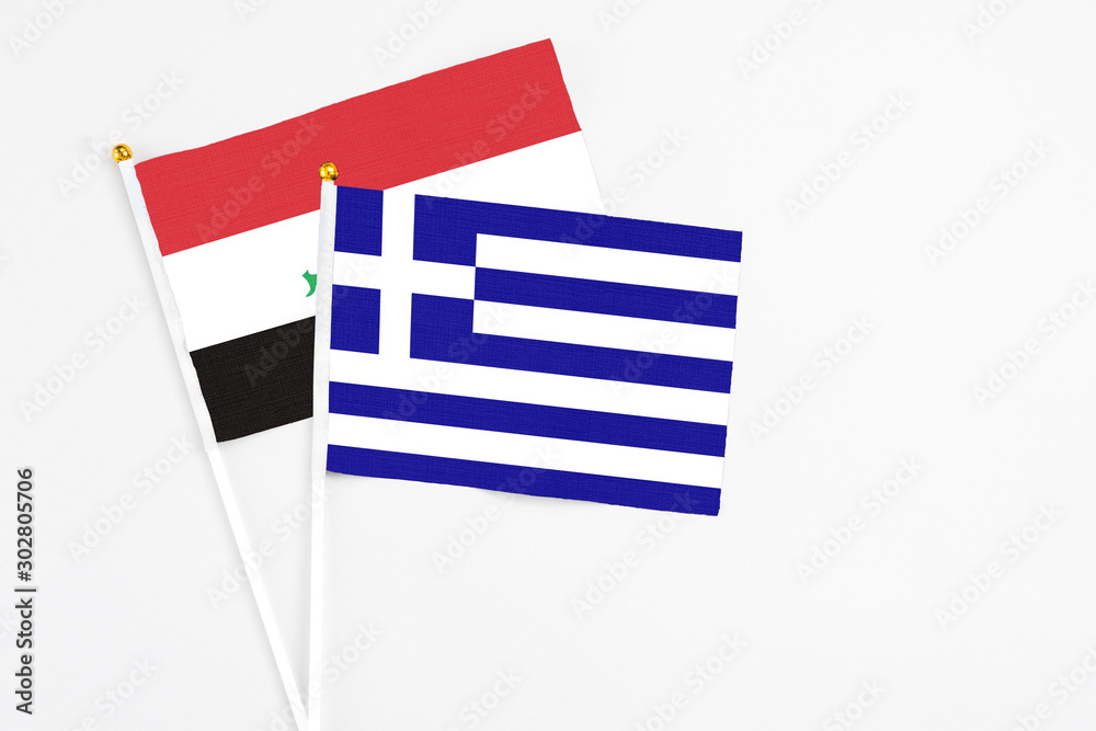 Obraz premium Greece and Iraq stick flags on white background. High quality fabric, miniature national flag. Peaceful global concept.White floor for copy space.
