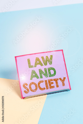 Word writing text Law And Society. Business photo showcasing Address the mutual relationship between law and society Paper placed tilted above buffer wire on soft pastel multi colours backdrop photo