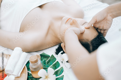 Beautiful young woman lying down on beds massage and spa at asian spa massage and beauty salon center, spa concept, massage concept