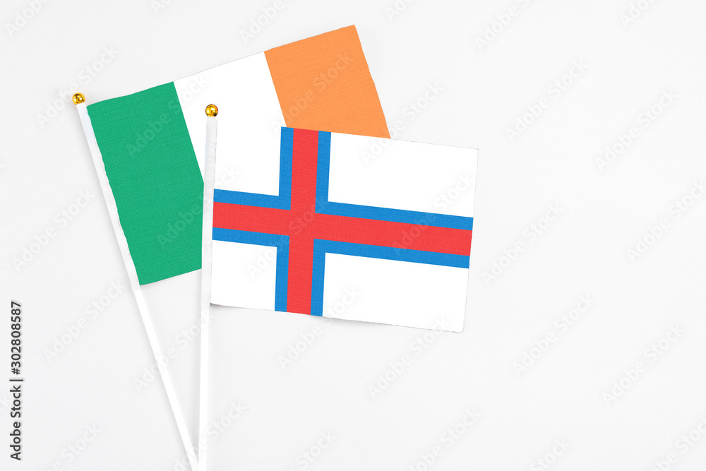 Faroe Islands and Ireland stick flags on white background. High quality fabric, miniature national flag. Peaceful global concept.White floor for copy space