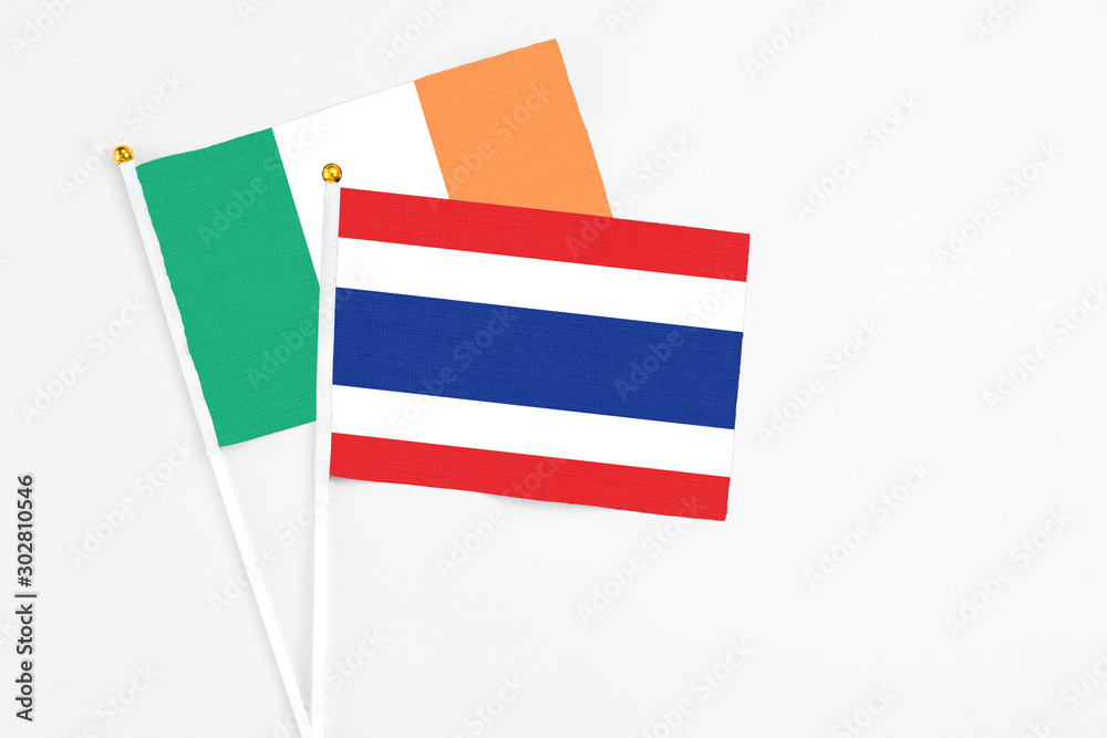 Thailand and Ireland stick flags on white background. High quality fabric, miniature national flag. Peaceful global concept.White floor for copy space