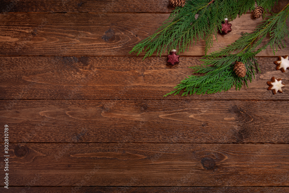 Christmas or New Year decoration background. Cypress branches with cones and balls on dark wooden background. Flat lay, top view, copy space. Christmas or New Year decoration background. Cypress branches with cones and balls on dark wooden background. Flat lay, top view, copy space.
