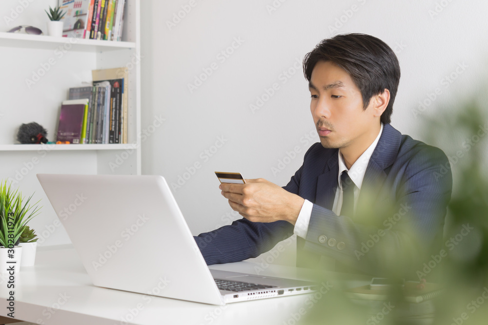 Asian Businessman Fill Credit Card Information for Online Shopping Asian Businessman Fill Credit Card Information for Online Shopping