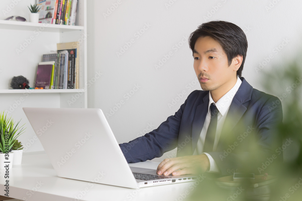 Asian Businessman In front of Laptop Monitor and Tree Foreground Asian Businessman In front of Laptop Monitor and Tree Foreground