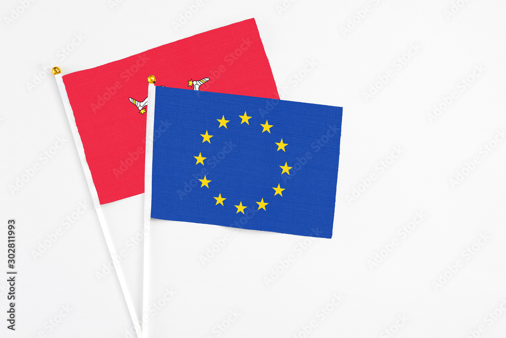 European Union and Isle Of Man stick flags on white background. High quality fabric, miniature national flag. Peaceful global concept.White floor for copy space. European Union and Isle Of Man stick flags on white background. High quality fabric, miniature national flag. Peaceful global concept.White floor for copy space.