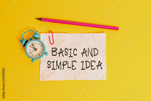 Conceptual hand writing showing Basic And Simple Idea. Concept meaning Plain Mental Images or Suggestions a Common Perception Metal alarm clock ccrushed sheet pencil colored background photo