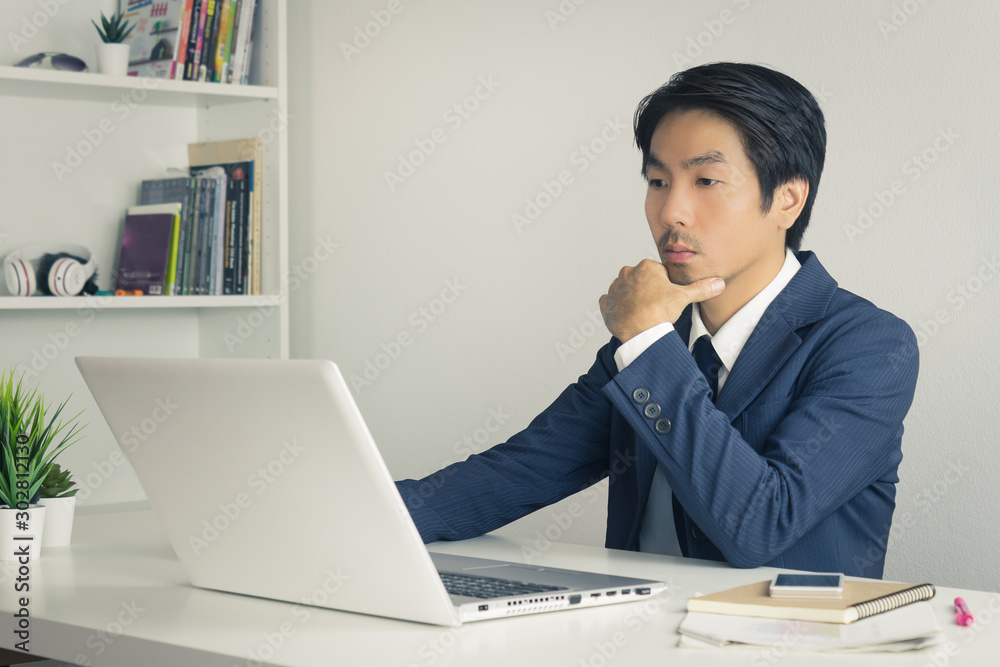 Asian Financial Advisor or Asian Consulting Businessman Thinking in front of Laptop in Vintage Tone
