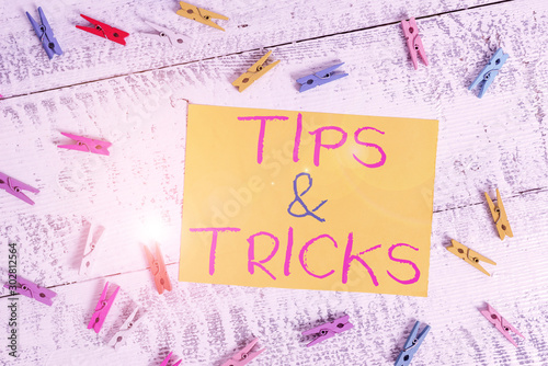 Conceptual hand writing showing Tips And Tricks. Concept meaning Steps Lifehacks Handy advice Recommendations Skills Colored clothespin rectangle shaped paper blue background photo