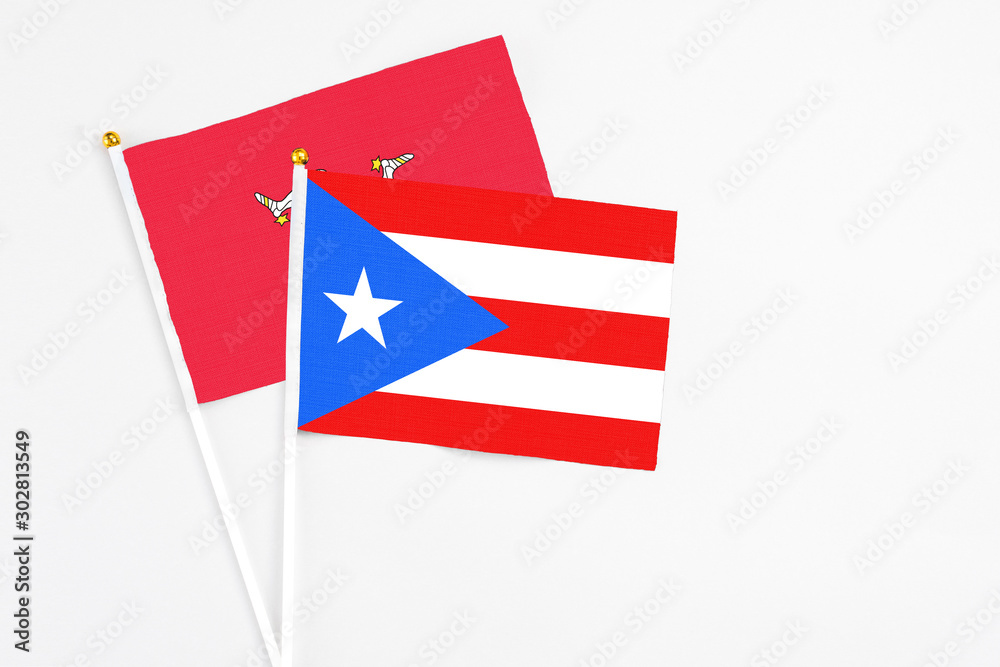 Puerto Rico and Isle Of Man stick flags on white background. High quality fabric, miniature national flag. Peaceful global concept.White floor for copy space.
