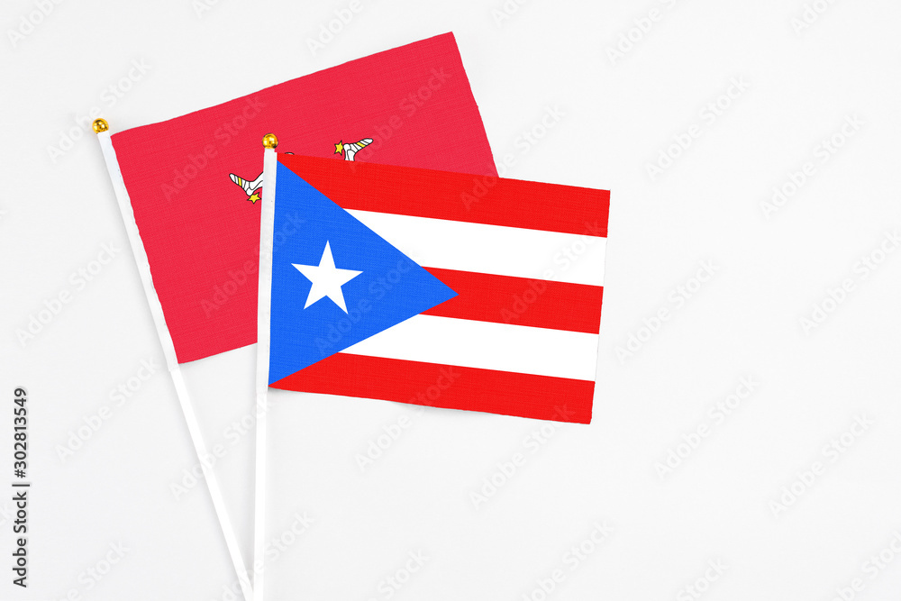 Puerto Rico and Isle Of Man stick flags on white background. High quality fabric, miniature national flag. Peaceful global concept.White floor for copy space. Puerto Rico and Isle Of Man stick flags on white background. High quality fabric, miniature national flag. Peaceful global concept.White floor for copy space.