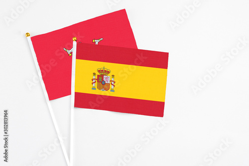 Spain and Isle Of Man stick flags on white background. High quality fabric, miniature national flag. Peaceful global concept.White floor for copy space.