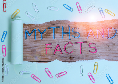 Writing note showing Myths And Facts. Business concept for Oppositive concept about modern and ancient period Paper clip and torn cardboard on wood classic table backdrop photo