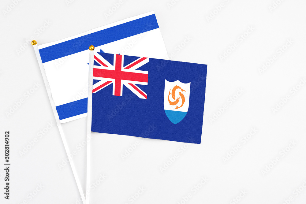 Fototapeta premium Anguilla and Israel stick flags on white background. High quality fabric, miniature national flag. Peaceful global concept.White floor for copy space.