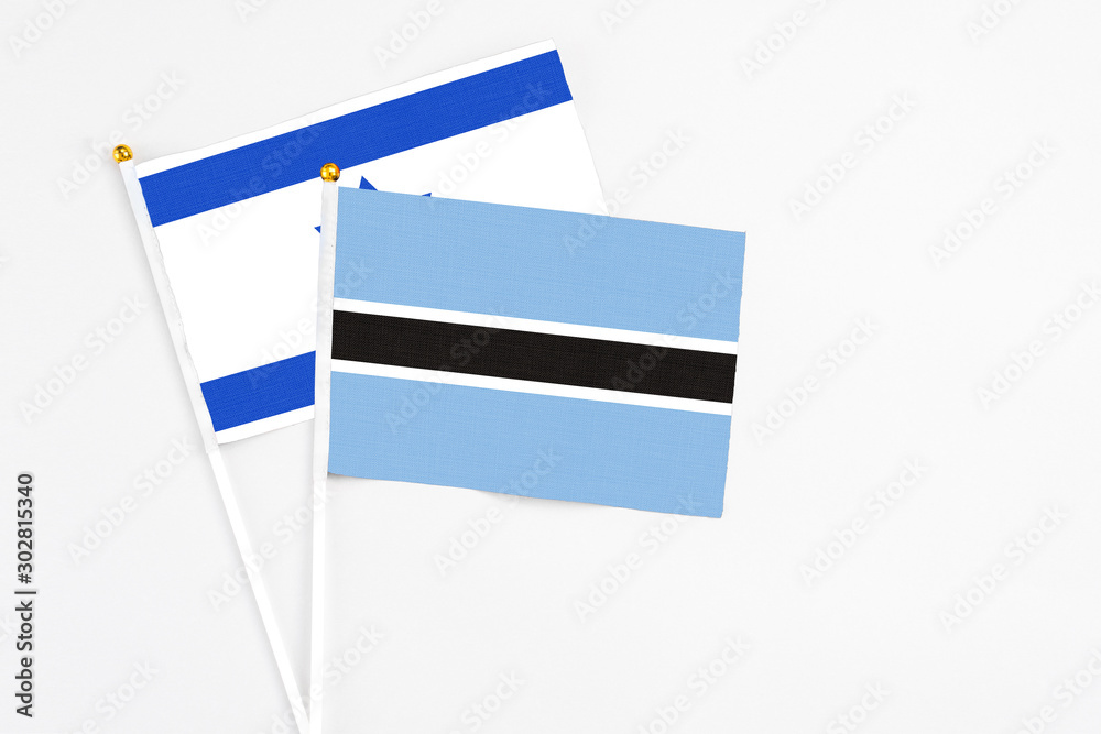 Botswana and Israel stick flags on white background. High quality fabric, miniature national flag. Peaceful global concept.White floor for copy space. Botswana and Israel stick flags on white background. High quality fabric, miniature national flag. Peaceful global concept.White floor for copy space.