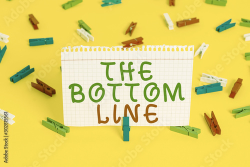 Handwriting text The Bottom Line. Conceptual photo asking someone to start doing Good perforanalysisce Encourage Colored clothespin papers empty reminder yellow floor background office
