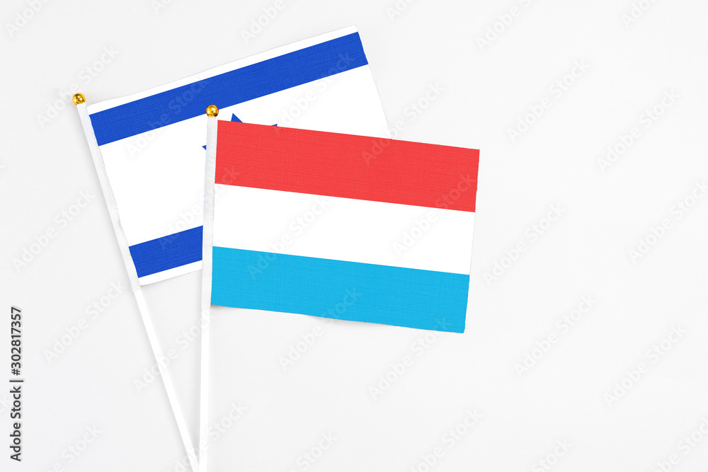 Luxembourg and Israel stick flags on white background. High quality fabric, miniature national flag. Peaceful global concept.White floor for copy space. Luxembourg and Israel stick flags on white background. High quality fabric, miniature national flag. Peaceful global concept.White floor for copy space.