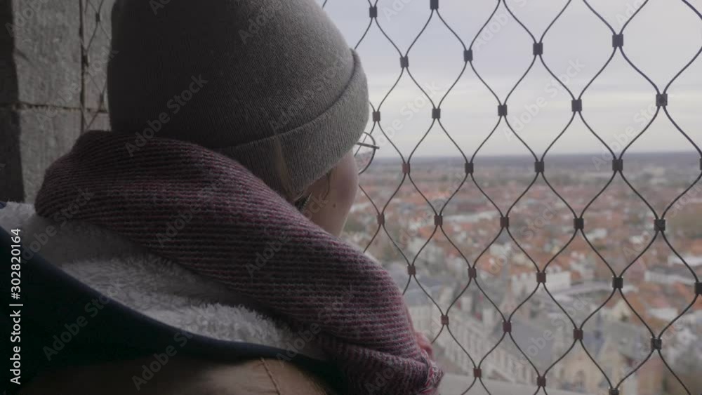 Young attractive girl enjoying the view on city of Bruges from above