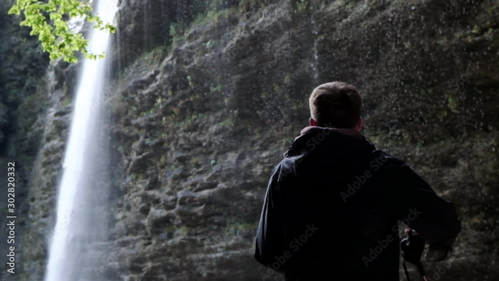 The beautiful waterfall of Pericnik Waterfall in Slovenia. Man capturing a image of the waterfall falling in slow motion The beautiful waterfall of Pericnik Waterfall in Slovenia. Man capturing a image of the waterfall falling in slow motion