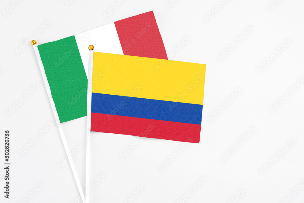Colombia and Italy stick flags on white background. High quality fabric, miniature national flag. Peaceful global concept.White floor for copy space. Colombia and Italy stick flags on white background. High quality fabric, miniature national flag. Peaceful global concept.White floor for copy space.