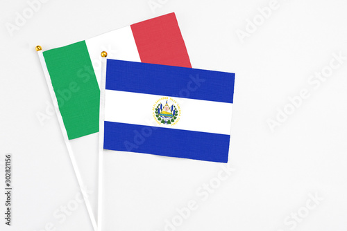 El Salvador and Italy stick flags on white background. High quality fabric, miniature national flag. Peaceful global concept.White floor for copy space.