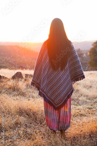 Photo indigenous woman with a poncho in the sunset
