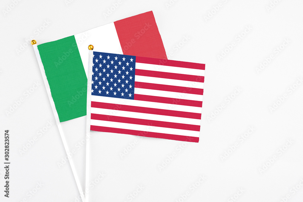 United States and Italy stick flags on white background. High quality fabric, miniature national flag. Peaceful global concept.White floor for copy space.