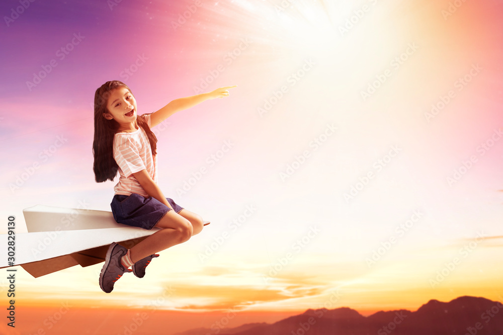 happy little girl on paper plane and flying in the sky Stock Photo ...
