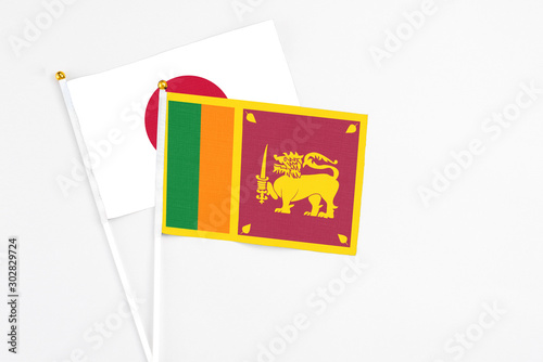 Sri Lanka and Japan stick flags on white background. High quality fabric, miniature national flag. Peaceful global concept.White floor for copy space.