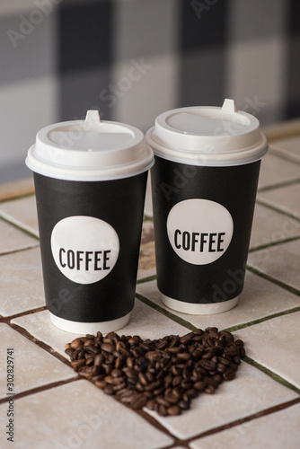 Сoffee paper cups with coffee beans on the table