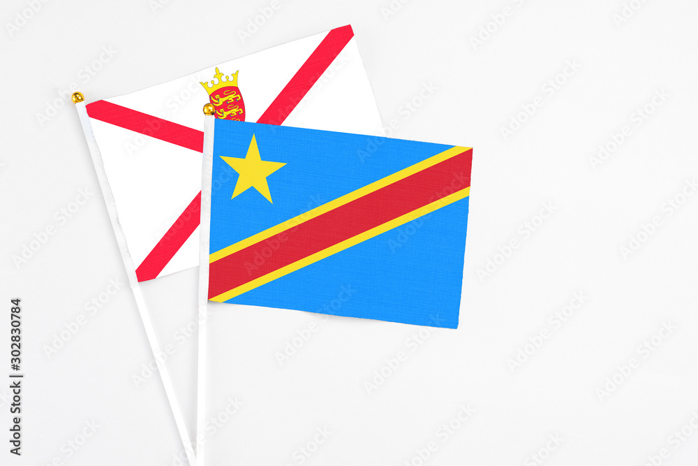 Obraz premium Congo and Jersey stick flags on white background. High quality fabric, miniature national flag. Peaceful global concept.White floor for copy space.