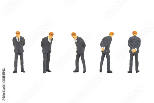 Miniature figurine character as businessman standing and working in posture isolated on white background.