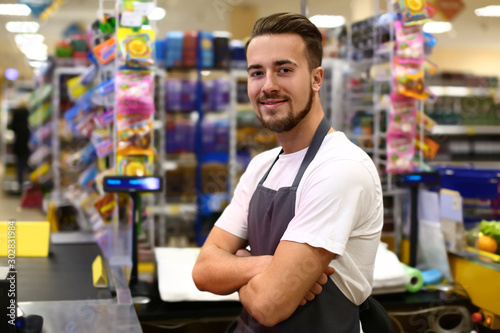 Portrait of male cashier in supermarket