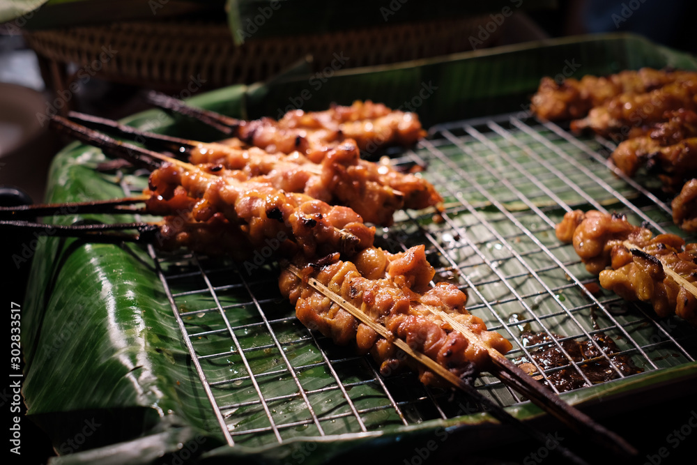 v=Ready-to-serve grilled chicken skewers on banana leaves