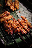 Ready-to-serve grilled chicken skewers on banana leaves