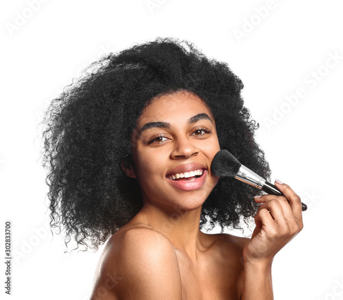 Portrait of beautiful African-American woman with makeup brush on white background