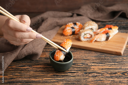 Εκτύπωση καμβά Woman dipping tasty sushi in soy sauce