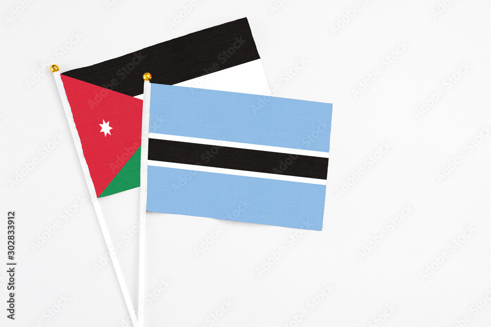 Botswana and Jordan stick flags on white background. High quality fabric, miniature national flag. Peaceful global concept.White floor for copy space. Botswana and Jordan stick flags on white background. High quality fabric, miniature national flag. Peaceful global concept.White floor for copy space.