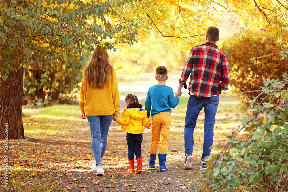 Happy family walking in autumn park