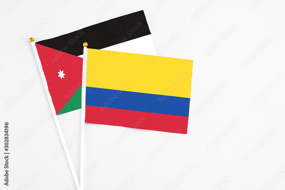Colombia and Jordan stick flags on white background. High quality fabric, miniature national flag. Peaceful global concept.White floor for copy space. Colombia and Jordan stick flags on white background. High quality fabric, miniature national flag. Peaceful global concept.White floor for copy space.