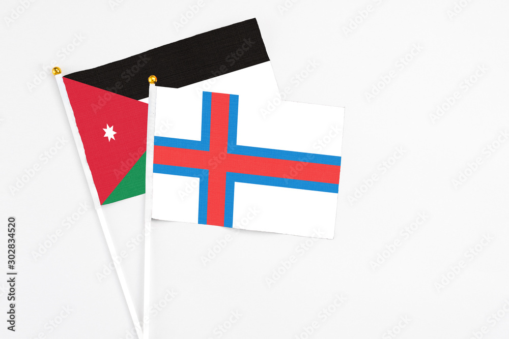 Faroe Islands and Jordan stick flags on white background. High quality fabric, miniature national flag. Peaceful global concept.White floor for copy space.