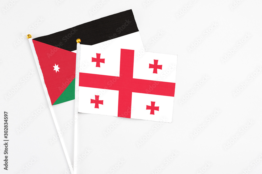 Georgia and Jordan stick flags on white background. High quality fabric, miniature national flag. Peaceful global concept.White floor for copy space.