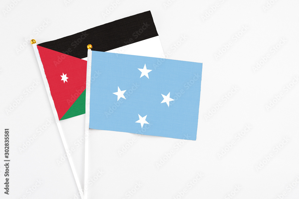 Micronesia and Jordan stick flags on white background. High quality fabric, miniature national flag. Peaceful global concept.White floor for copy space. Micronesia and Jordan stick flags on white background. High quality fabric, miniature national flag. Peaceful global concept.White floor for copy space.