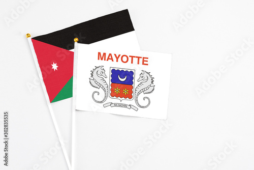 Mayotte and Jordan stick flags on white background. High quality fabric, miniature national flag. Peaceful global concept.White floor for copy space.