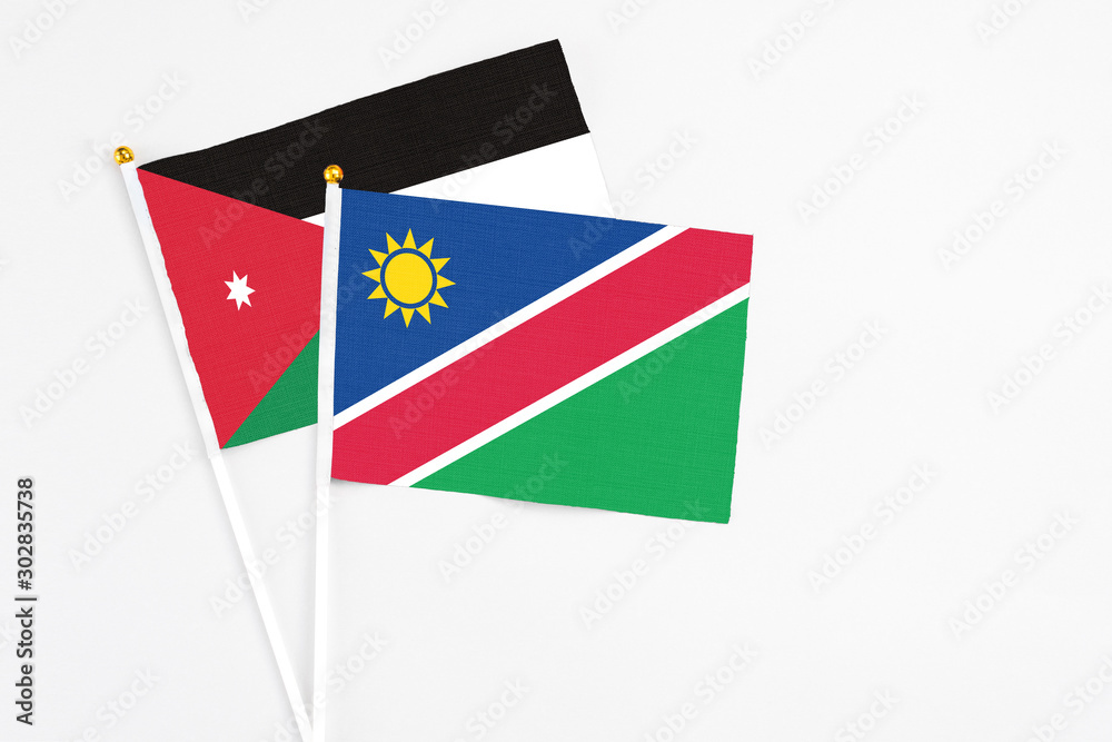 Namibia and Jordan stick flags on white background. High quality fabric, miniature national flag. Peaceful global concept.White floor for copy space. Namibia and Jordan stick flags on white background. High quality fabric, miniature national flag. Peaceful global concept.White floor for copy space.