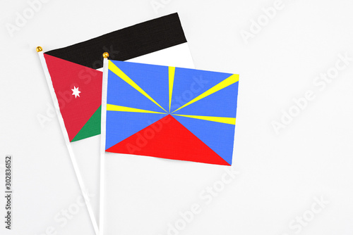 Reunion and Jordan stick flags on white background. High quality fabric, miniature national flag. Peaceful global concept.White floor for copy space.