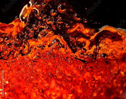 Alcoholic drink on a dark background, abstract splashing.