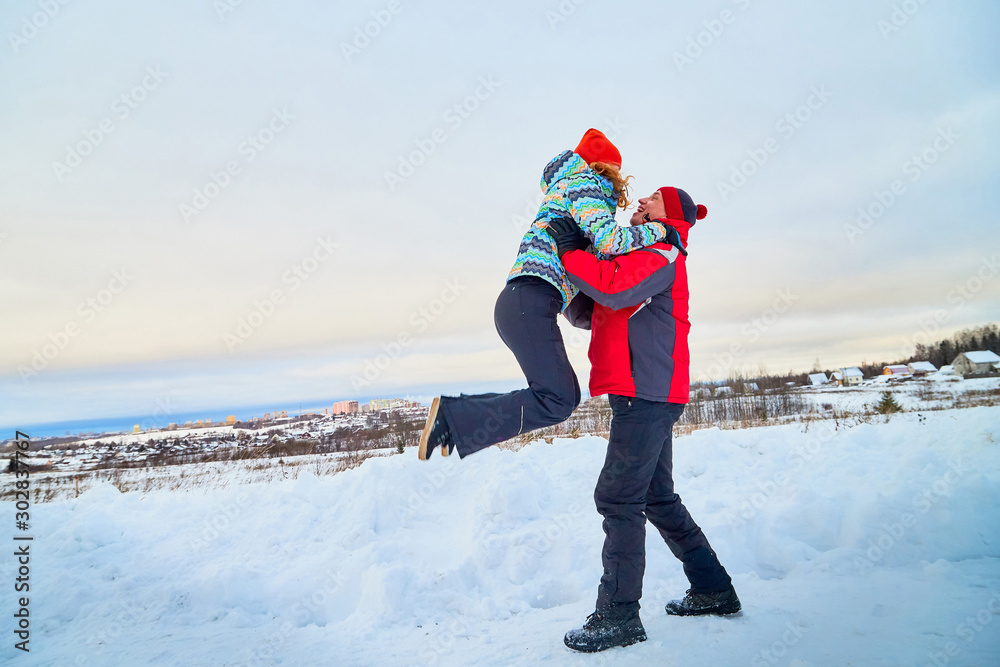 Happy pair of male and female in warm clothes together outside in field