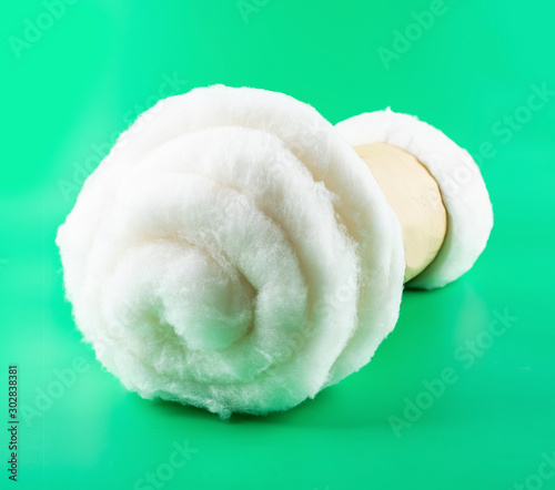 A roll of Chinese Xinjiang long-staple cotton on a green background
