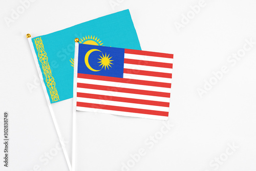 Malaysia and Kazakhstan stick flags on white background. High quality fabric, miniature national flag. Peaceful global concept.White floor for copy space.