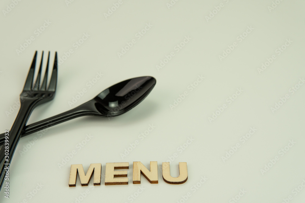 Selective focus of black shine spoon and fork with white background. Food or restaurant concept. Selective focus of black shine spoon and fork with white background. Food or restaurant concept.